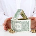 Hard money loan financing concept showing a California house model next to stacks of cash, representing ARC Private Lending real estate funding.